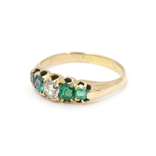 619 - An 18ct gold ring set with central diamond flanked by two emeralds. Together with insurance valuatio... 