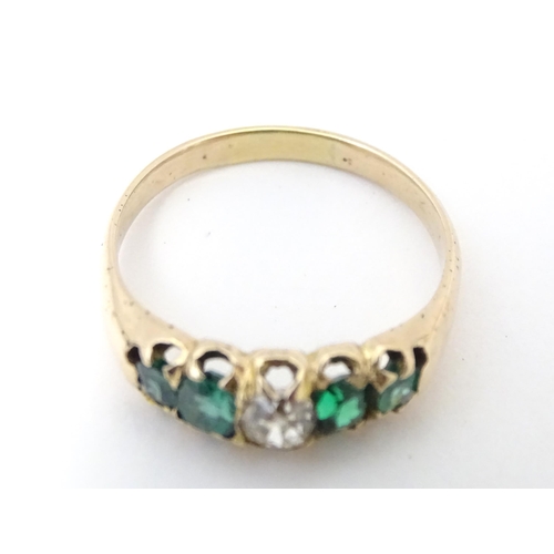 619 - An 18ct gold ring set with central diamond flanked by two emeralds. Together with insurance valuatio... 