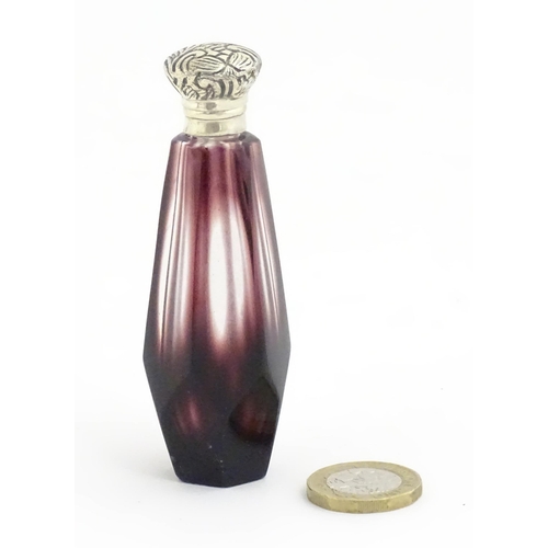 1147 - A scent / perfume bottle with white metal top and amethyst style facet cut glass body. Approx. 3 1/2... 