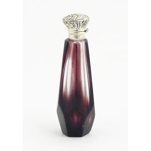 1147 - A scent / perfume bottle with white metal top and amethyst style facet cut glass body. Approx. 3 1/2... 