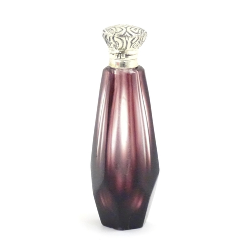 1147 - A scent / perfume bottle with white metal top and amethyst style facet cut glass body. Approx. 3 1/2... 