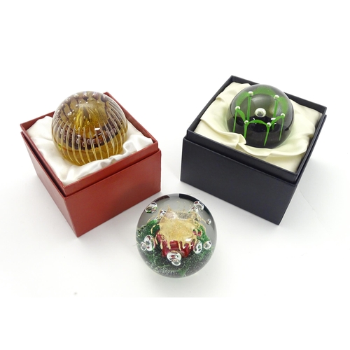 176 - Three assorted paperweights to include an example by Langham glass designed by Paul Miller, together... 