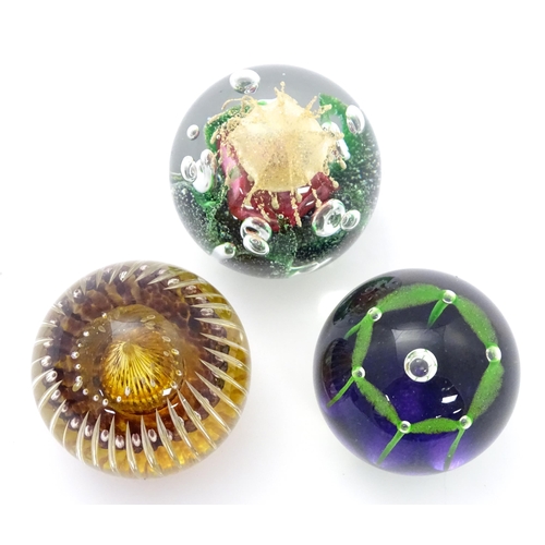 176 - Three assorted paperweights to include an example by Langham glass designed by Paul Miller, together... 