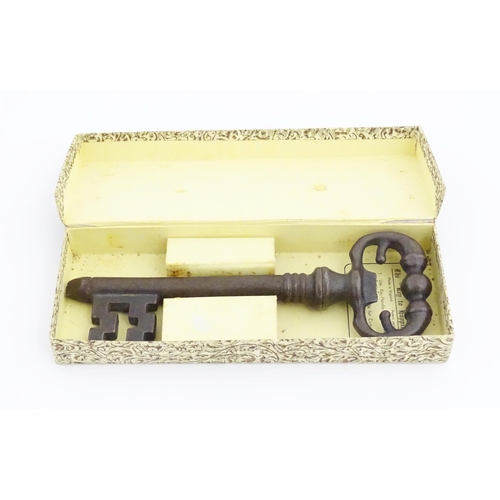 1063 - A 20thC novelty corkscrew / bottle opener modelled as an old key, titled The Key to Happiness. In or... 