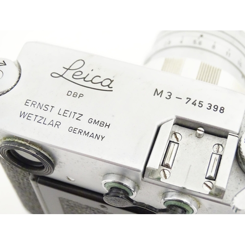 1112 - A cased Leica M3 camera with two additional lenses to include a 1:4/90mm lens fitted with a Hoya 39m... 