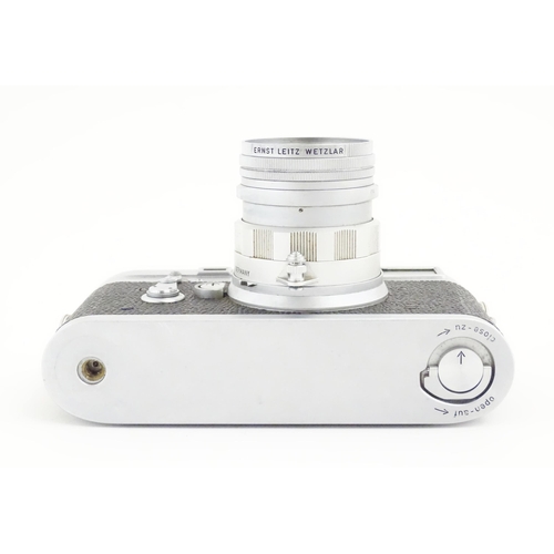 1112 - A cased Leica M3 camera with two additional lenses to include a 1:4/90mm lens fitted with a Hoya 39m... 