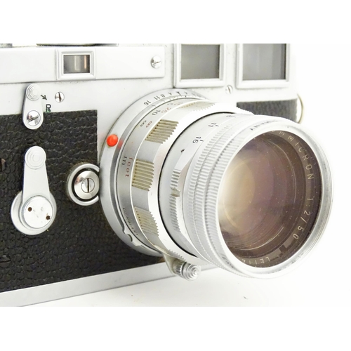 1112 - A cased Leica M3 camera with two additional lenses to include a 1:4/90mm lens fitted with a Hoya 39m... 