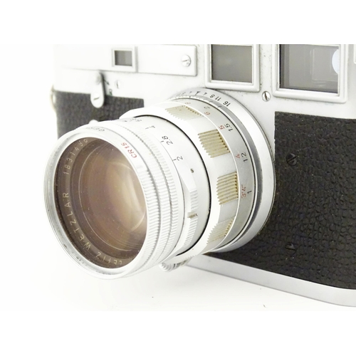 1112 - A cased Leica M3 camera with two additional lenses to include a 1:4/90mm lens fitted with a Hoya 39m... 