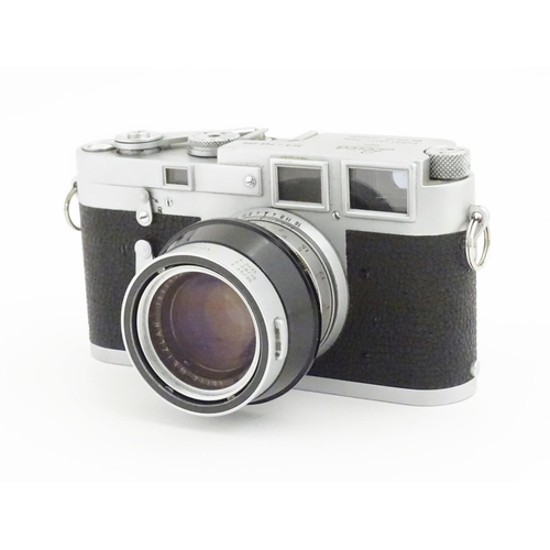 1112 - A cased Leica M3 camera with two additional lenses to include a 1:4/90mm lens fitted with a Hoya 39m... 