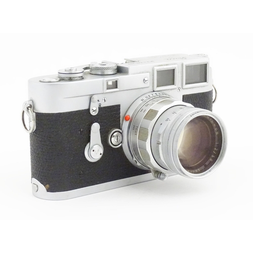 1112 - A cased Leica M3 camera with two additional lenses to include a 1:4/90mm lens fitted with a Hoya 39m... 