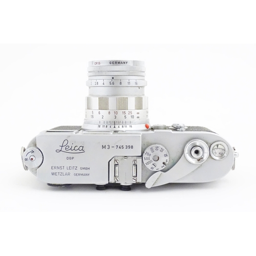 1112 - A cased Leica M3 camera with two additional lenses to include a 1:4/90mm lens fitted with a Hoya 39m... 