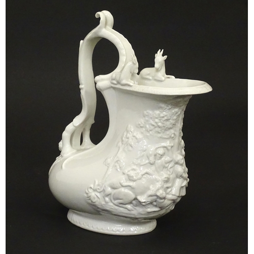 72 - A Continental white glazed jug with relief decoration depicting a wild boar hunt, the rim with goat ... 