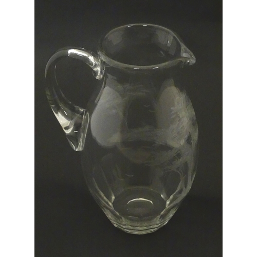 203 - A glass jug with loop handle decorated with etched Alpine Ibex in landscape. Approx 10