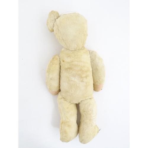 822 - Toy: A 20thC plush teddy bear with stitched nose, mouth, eyes and paws. Approx. 19 1/2