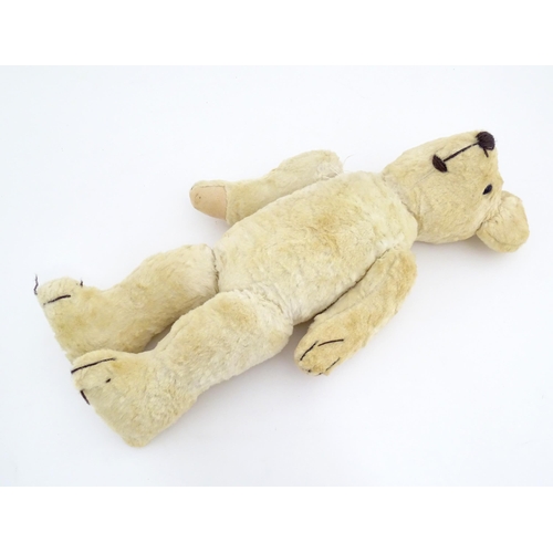 822 - Toy: A 20thC plush teddy bear with stitched nose, mouth, eyes and paws. Approx. 19 1/2