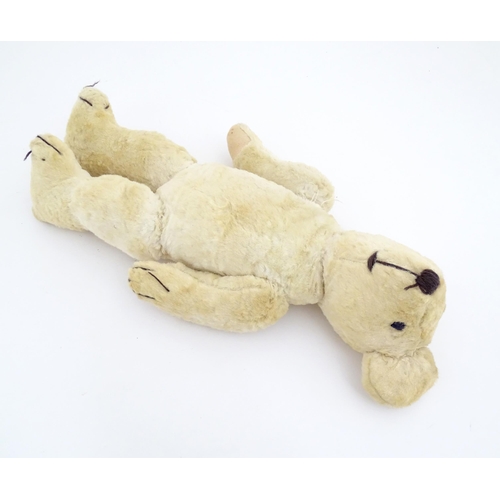 822 - Toy: A 20thC plush teddy bear with stitched nose, mouth, eyes and paws. Approx. 19 1/2