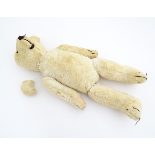 822 - Toy: A 20thC plush teddy bear with stitched nose, mouth, eyes and paws. Approx. 19 1/2