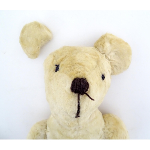 822 - Toy: A 20thC plush teddy bear with stitched nose, mouth, eyes and paws. Approx. 19 1/2