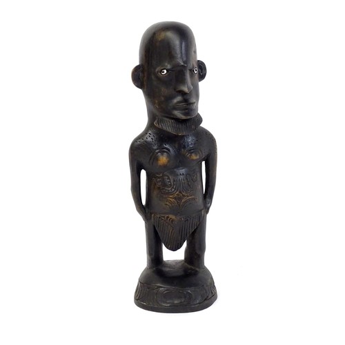5 - Ethnographic / Native / Tribal: An African carved hardwood figure with inlaid eyes and carved decora... 