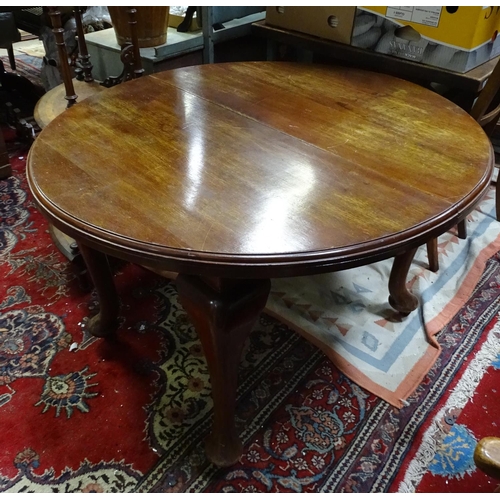60 - A mahogany oval dining table with cabriole legs and pad feet. Approx 45 3/4