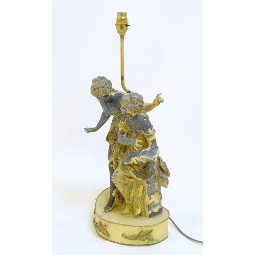 73 - A mid 20thC table lamp, of metal construction and decorated with two singing maidens standing on a s... 