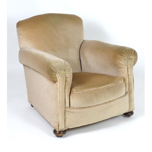 116 - A mid 20thC Howard style armchair with scrolled arms and raised on squat bun front feet and squared ... 