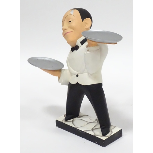 143 - A small novelty dumb waiter figure formed as a waiter holding two dishes. Approx 21 1/2