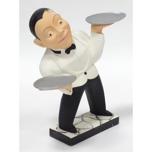 143 - A small novelty dumb waiter figure formed as a waiter holding two dishes. Approx 21 1/2