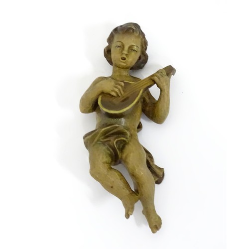 59 - A carved putto playing a lute. Approx. 9