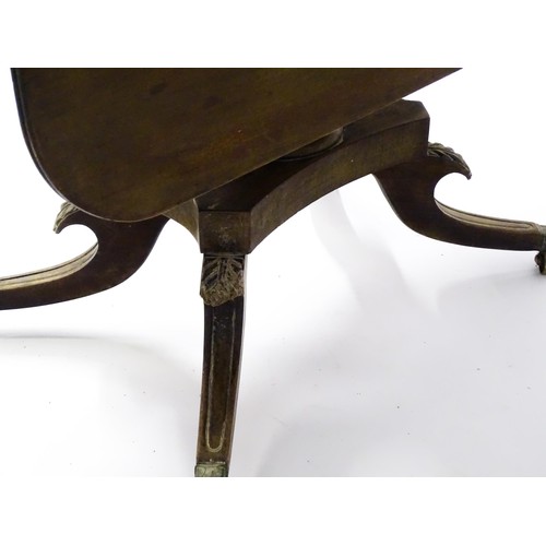 71 - A mid 19thC mahogany sofa table with drop flaps to either side, a turned column to the centre and ra... 