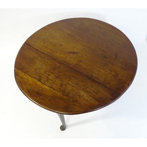 65 - A late Georgian mahogany drop flap table, the table having two demi lune leaves and raised on turned... 