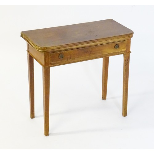 42 - A late 19thC / early 20thC mahogany fold over card table with a single short drawer above four turne... 