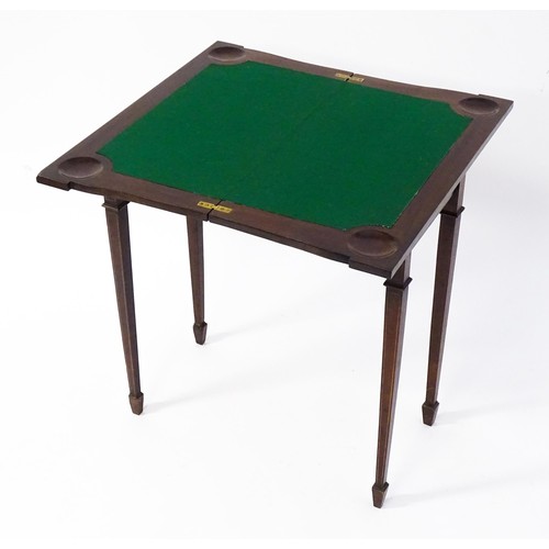 77 - A late 19thC / early 20thC mahogany card table with satinwood inlay, a crossbanded top and tapering ... 