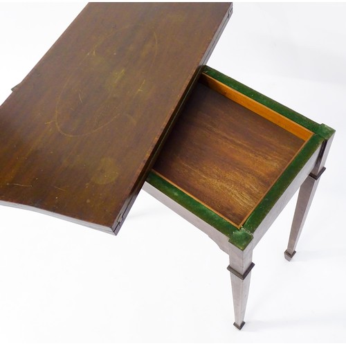 77 - A late 19thC / early 20thC mahogany card table with satinwood inlay, a crossbanded top and tapering ... 