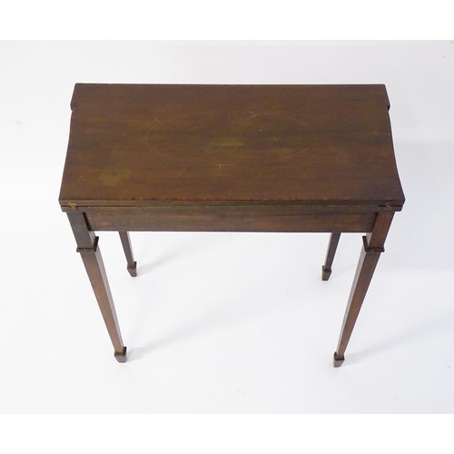 77 - A late 19thC / early 20thC mahogany card table with satinwood inlay, a crossbanded top and tapering ... 