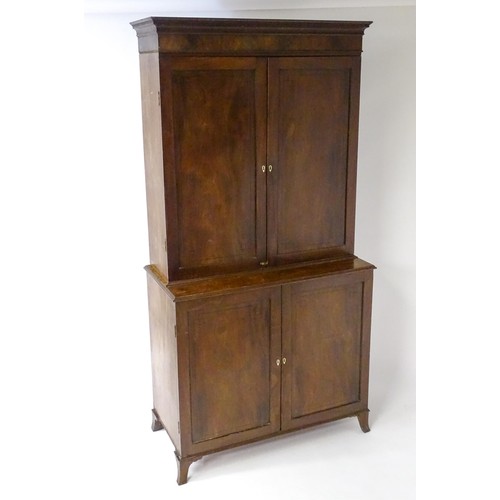 82 - A late Georgian mahogany linen press with a moulded cornice above two sections with panelled doors h... 