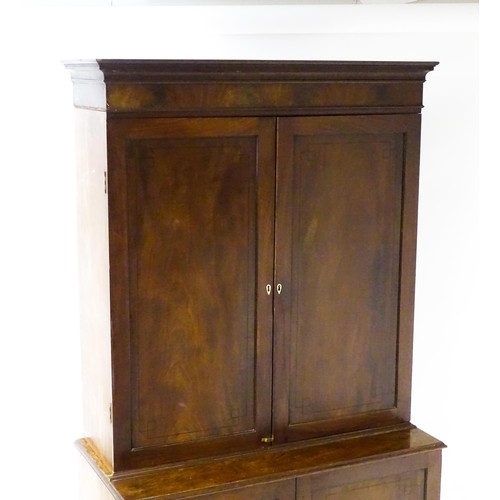 82 - A late Georgian mahogany linen press with a moulded cornice above two sections with panelled doors h... 