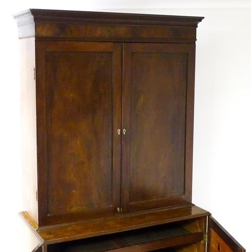 82 - A late Georgian mahogany linen press with a moulded cornice above two sections with panelled doors h... 