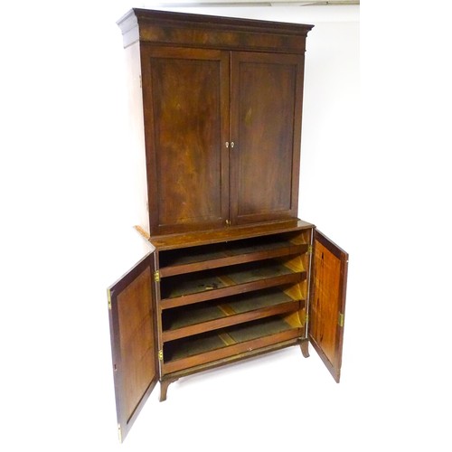 82 - A late Georgian mahogany linen press with a moulded cornice above two sections with panelled doors h... 