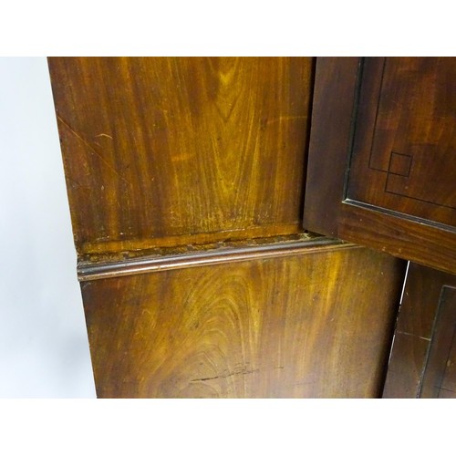 82 - A late Georgian mahogany linen press with a moulded cornice above two sections with panelled doors h... 