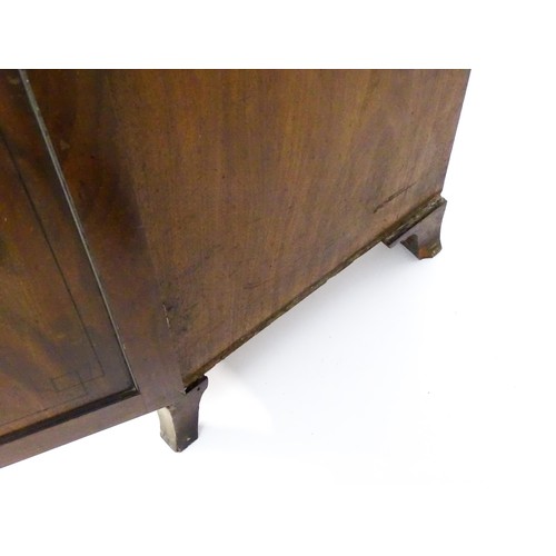 82 - A late Georgian mahogany linen press with a moulded cornice above two sections with panelled doors h... 