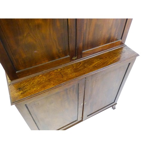 82 - A late Georgian mahogany linen press with a moulded cornice above two sections with panelled doors h... 