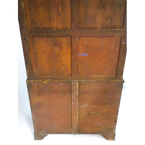 82 - A late Georgian mahogany linen press with a moulded cornice above two sections with panelled doors h... 