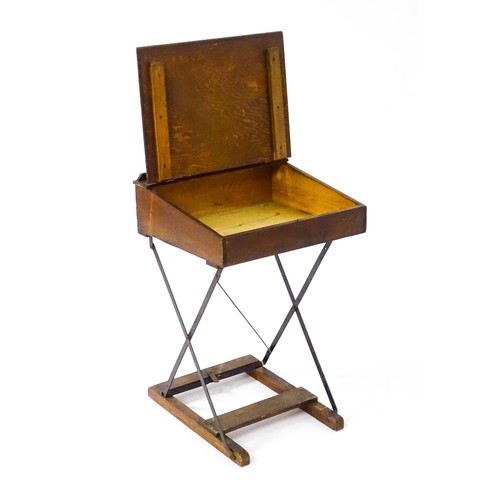 86 - A mid 20thC child's student desk, with a sloped hinged top and a metal and pine constructed folding ... 