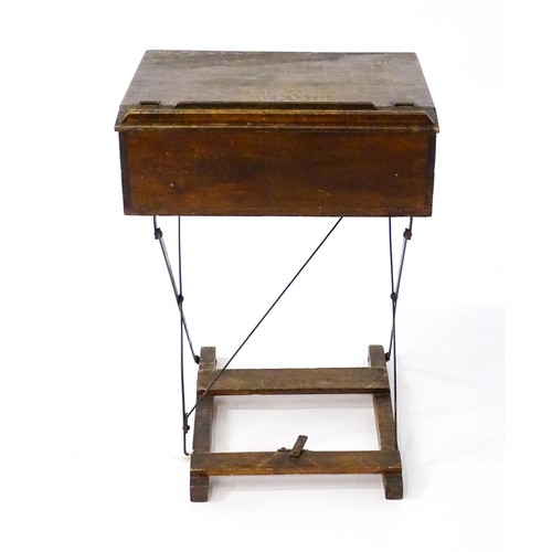 86 - A mid 20thC child's student desk, with a sloped hinged top and a metal and pine constructed folding ... 