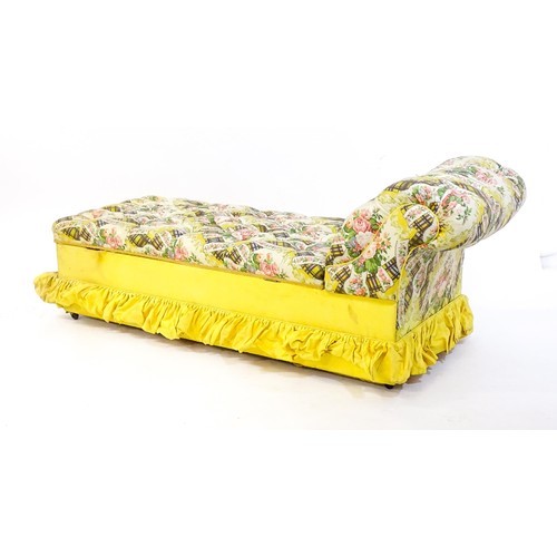 238 - An early / mid 20thC chaise longue with deep buttoned floral upholstery and raised on four castors. ... 