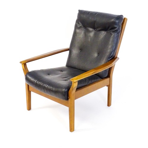 249 - A Cintique retro armchair with deep button upholstery, tapering arms and raised on four tapering leg... 