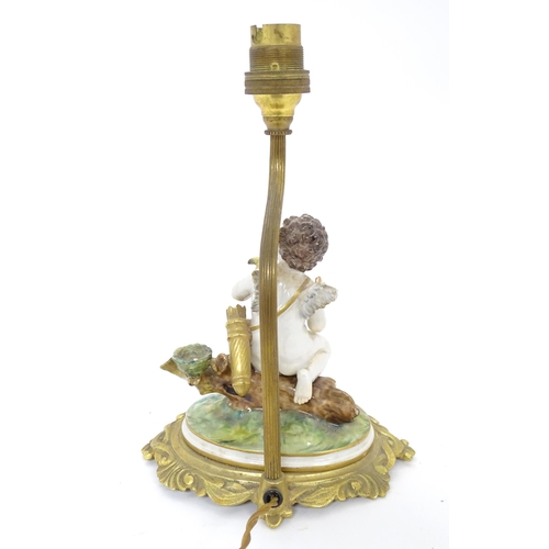 293 - A Continental gilt metal table lamp with ceramic figure depicting a cherub holding a bird. Bears old... 