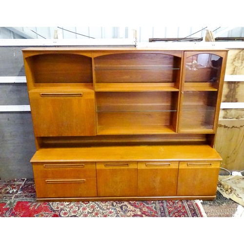 310 - Vintage / Retro: A Meredew two sectional teak sideboard, the top section having fitted shelves, a dr... 