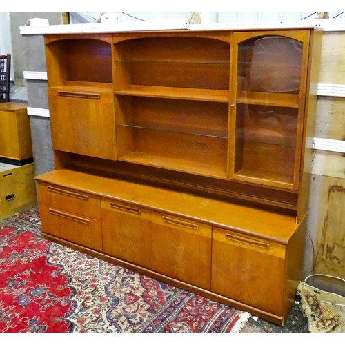 310 - Vintage / Retro: A Meredew two sectional teak sideboard, the top section having fitted shelves, a dr... 